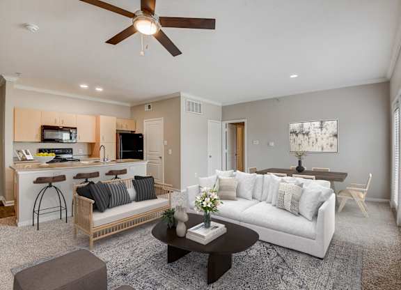 A living room with a white couch and a ceiling fan at Artisan Apartments & Shops, Austin, TX 78729
