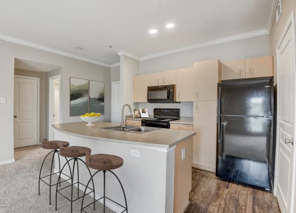 a kitchen with a large island with three stools at Artisan Apartments & Shops, Austin, TX