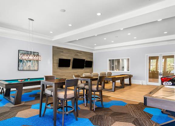 A room with a pool table and a dining table.