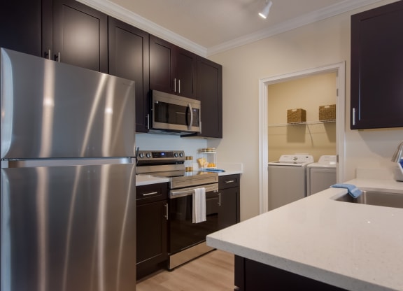 a kitchen with dark cabinets and white countertops  at The Oasis at Manatee River, Bradenton, FL, 34211