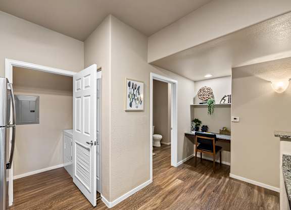 A kitchen with a refrigerator, a table, and a chair.