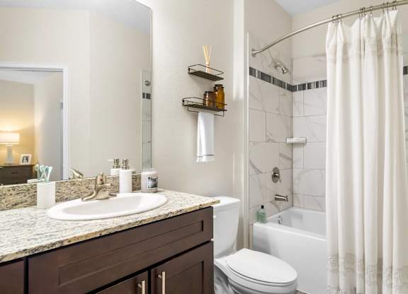 A bathroom with a marble countertop and a white toilet.