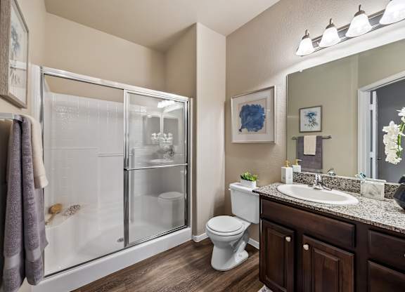 A bathroom with a toilet, sink, and shower.