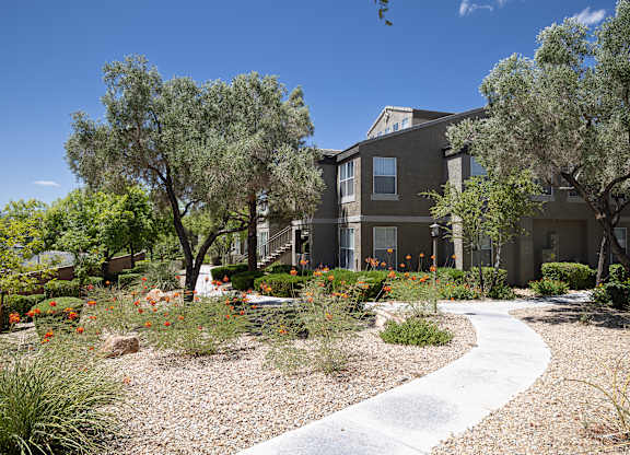 Walking path to a building surrounded by vegetation and trees.