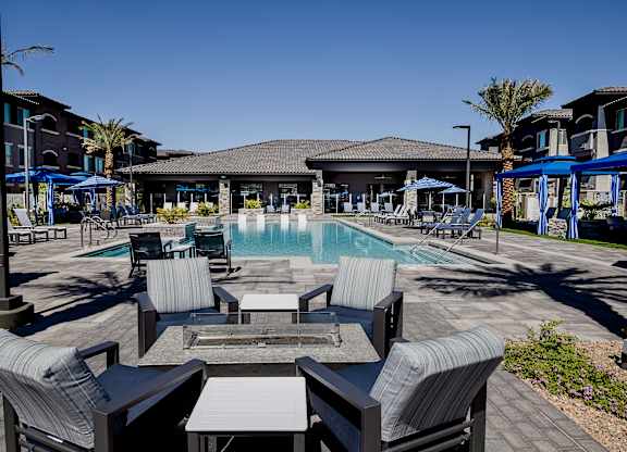 Poolside area with lounge chairs and a fire table at Level 25 at The Curve by Picerne, Las Vegas, NV