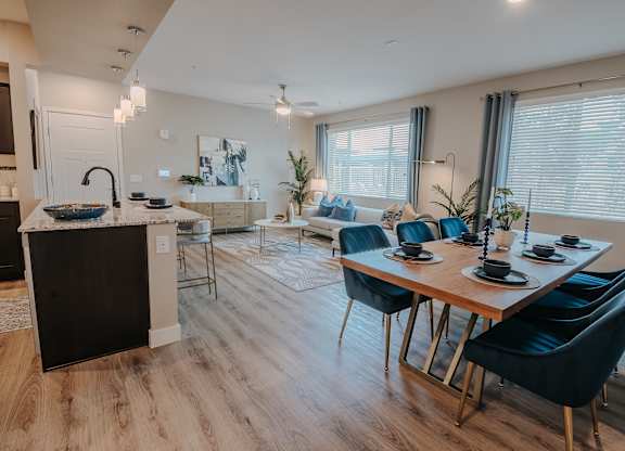 A modern kitchen with a dining table set at Level 25 at The Curve by Picerne, Las Vegas