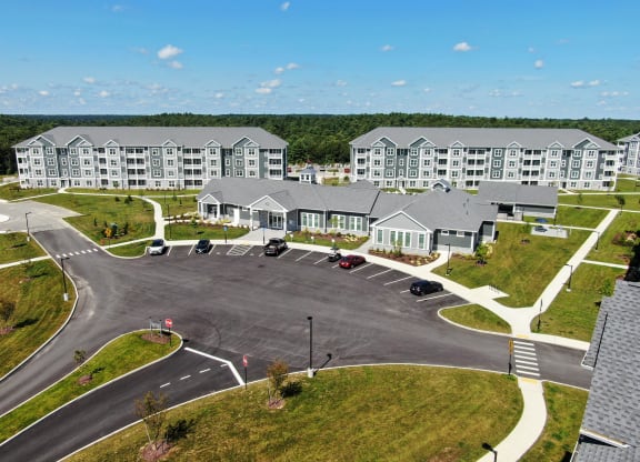 an aerial view of an apartment complex with a road and parking lot  at The Oasis at Plymouth, Plymouth, MA