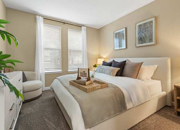 A bedroom with a large bed and a chair  at The Oasis at Lake Bennet, Ocoee, FL, 34761