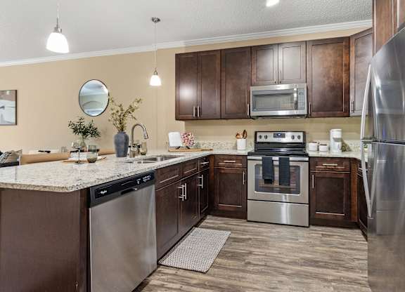 A modern kitchen with stainless steel appliances and wooden cabinets.