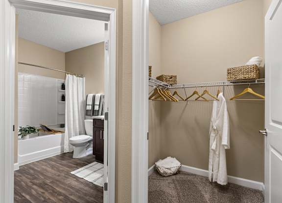 A white toilet is in a bathroom with a white shower curtain.