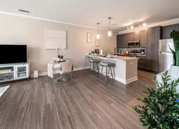 an open kitchen and living room with a dining area and a large tv at The Oasis at Plymouth, Massachusetts