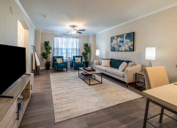 an open living room and dining room with a couch and chairs at The Oasis at Plymouth, Plymouth, MA, 02360