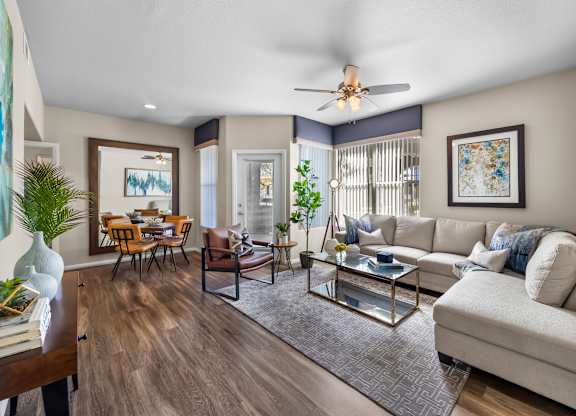 A living room with a white couch and a glass coffee table.