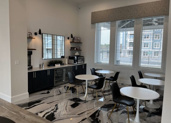 a common area with tables and chairs and a counter with a microwave and coffee maker at Plymouth, Plymouth, 02360