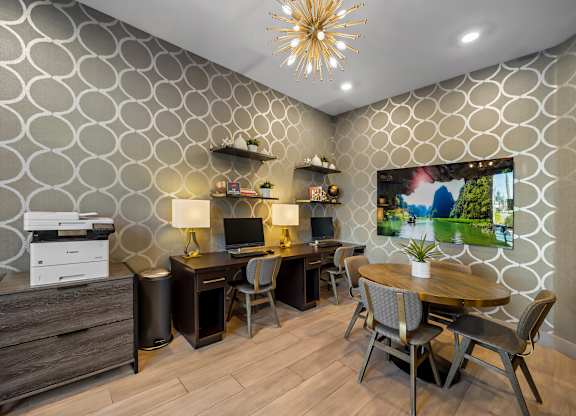 A modern home office with a patterned wallpaper and a wooden desk.