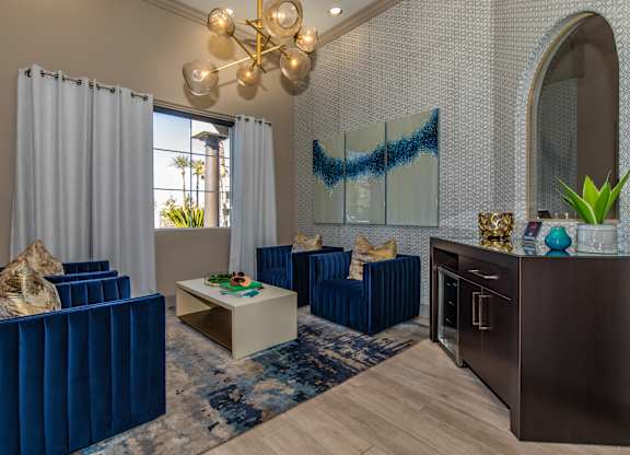 A living room with blue furniture and a chandelier.