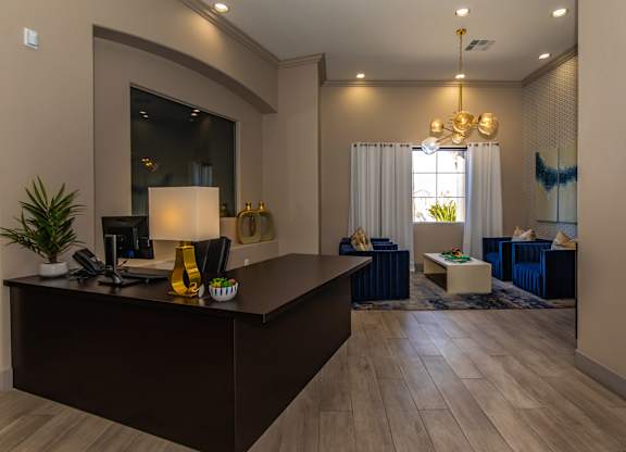 A modern office with a dark wood desk and a large mirror on the wall.