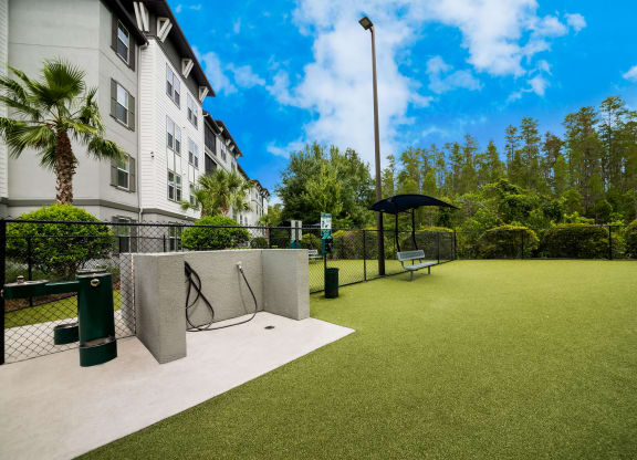 a tennis court in front of a building with an umbrella at The Oasis at Highwoods Preserve, Tampa