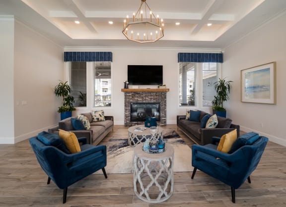 a living room with blue chairs and couches at The Oasis at Plymouth, Plymouth, MA