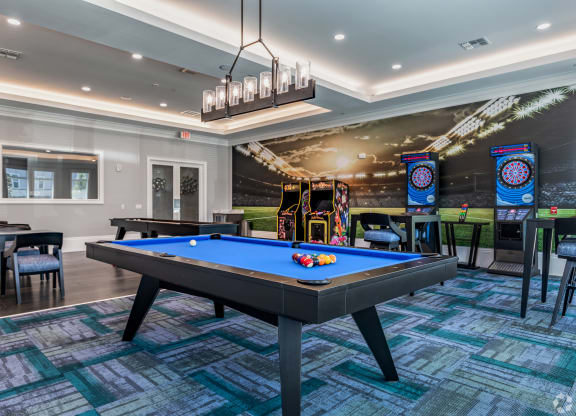 a game room with a pool table and arcade games at the sanctuary at kiawah at The Oasis at Manatee River, Bradenton, FL, 34211