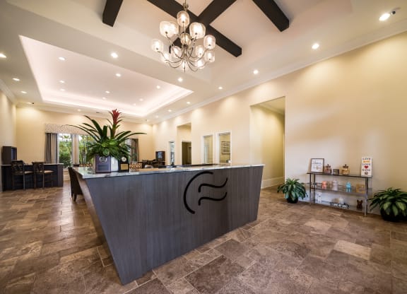 a lobby with a reception desk and a chandelier at The Oasis at Highwoods Preserve, Tampa, FL