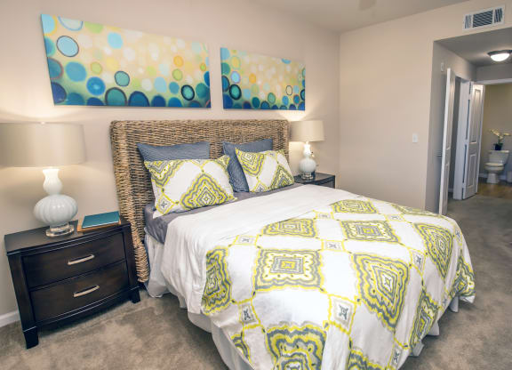 a yellow and white bed in a bedroom with a closet at Loreto & Palacio Apartments, Las Vegas, Nevada