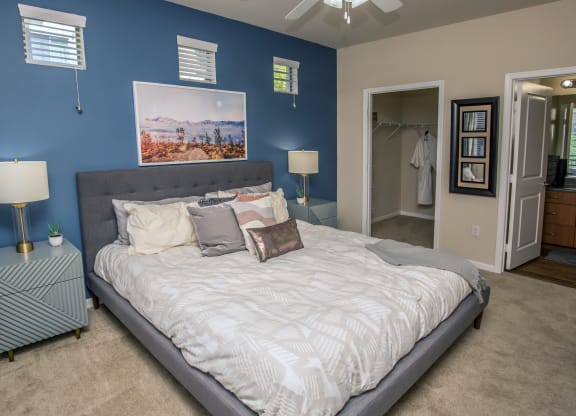 a bedroom with a large bed and a blue wall at Loreto & Palacio Apartments, Las Vegas, NV 89149