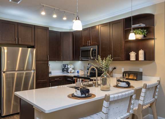 A kitchen with a white countertop and dark brown cabinets. at The Oasis at Highwoods Preserve, Tampa, FL
