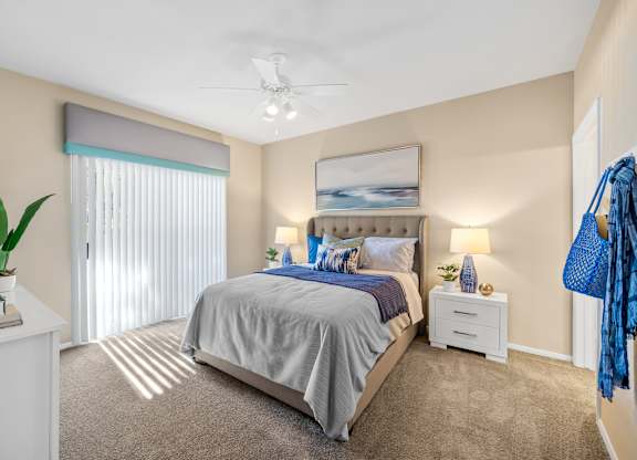 A bedroom with a large bed and a ceiling fan.