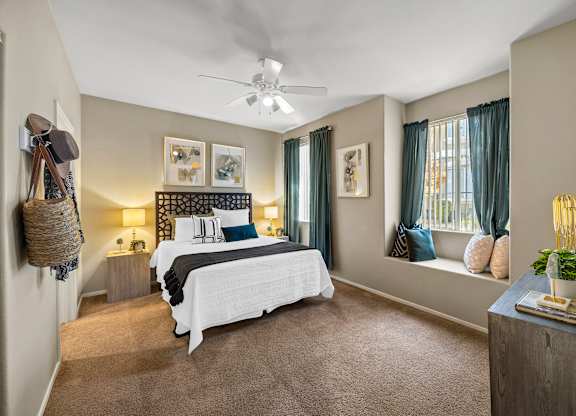 A bedroom with a large bed and a ceiling fan.
