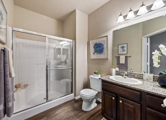 A bathroom with a toilet, sink, and shower.