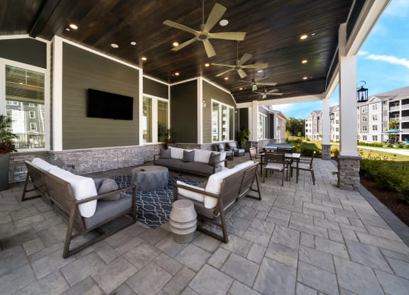 a covered patio with furniture and a tv at The Oasis at Plymouth, Massachusetts, 02360