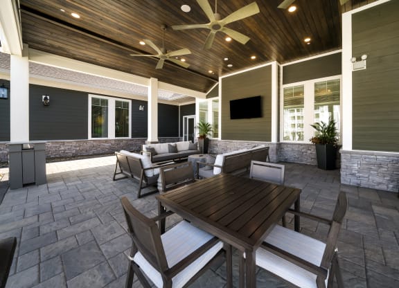 a covered patio with a table and chairs at The Oasis at Plymouth, Massachusetts