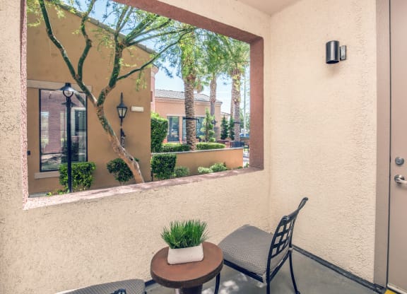 a patio with a chair and a table and a large window at Loreto & Palacio Apartments, Las Vegas, 89149