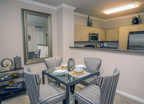 a dining room with a table and chairs and a kitchen at Loreto & Palacio Apartments, Las Vegas, Nevada