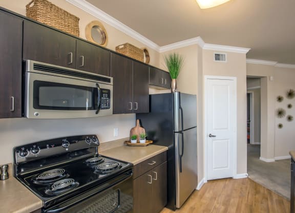 a kitchen with stainless steel appliances and a black refrigerator at Loreto & Palacio Apartments, Las Vegas, NV