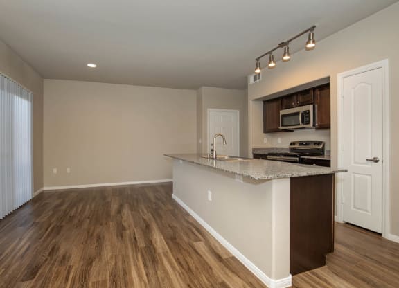wooden cabinets and appliances in kitchen and dining areaat The Cantera by Picerne, Las Vegas, NV