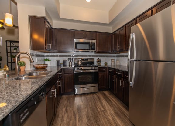 Kitchen with appliances and wooden cabinets at Level 25 at Cactus by Picerne, Las Vegas, NV