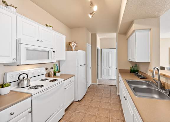 A kitchen with white appliances and cabinets. at The Fairways by Picerne, Nevada, 89141