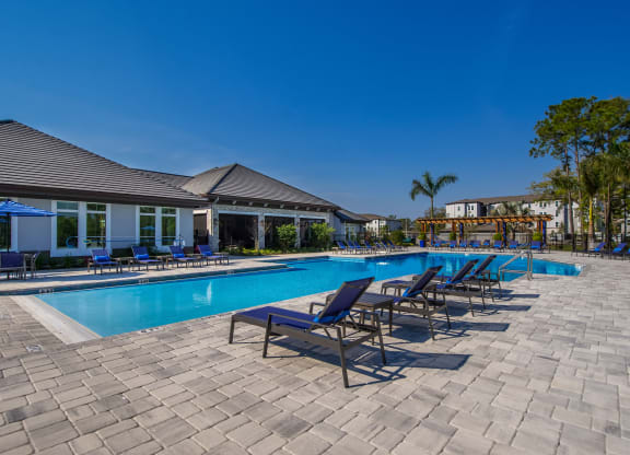 a resort style pool with lounge chairs and umbrellas  at The Oasis at Manatee River, Florida, 34211