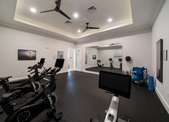 a gym with weights and cardio machines and a tv at The Oasis at Plymouth, Plymouth, Massachusetts