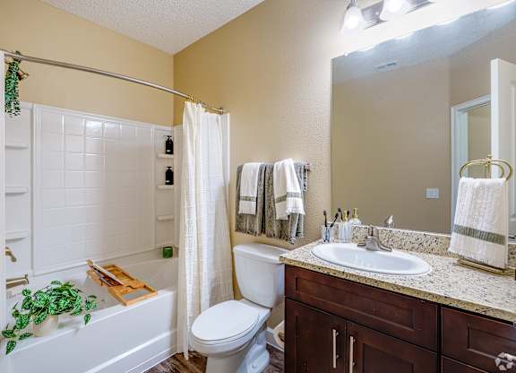 A bathroom with a white toilet, a white sink, and a white bathtub.