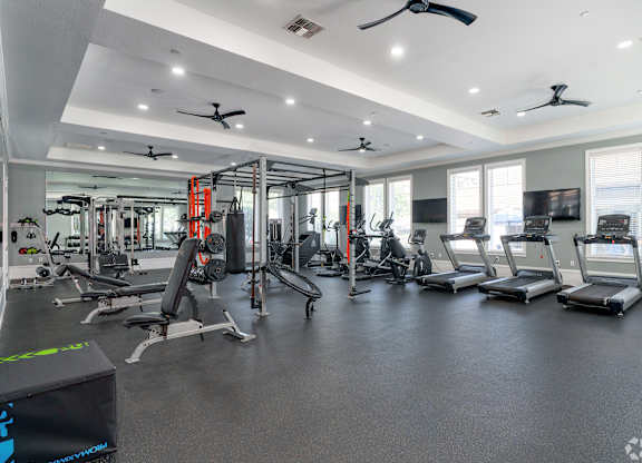 A spacious gym with various exercise equipment and a digital fitness tracker.