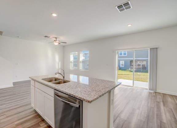 View from kitchen looking out to a sliding door leading to the backyard of the Verbena floor plan at Beacon at Clinton Corners in Dade City, FL