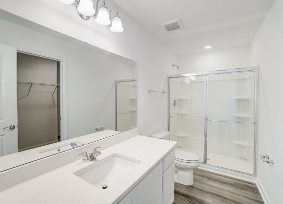 A bathroom with a sink and a stand-up shower in the Verbena floor plan at Beacon at Clinton Corners in Dade City, FL