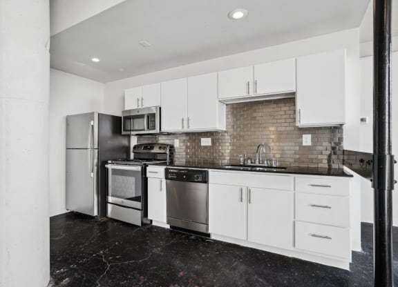 a kitchen with white cabinets and stainless steel appliances