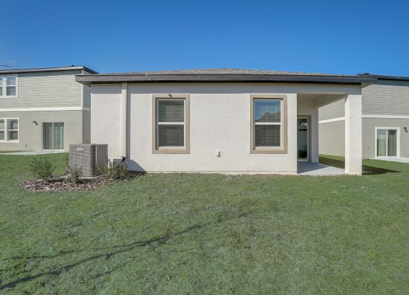 Backyard with lush green grass of the Oak floor plan at Beacon at Clinton Corners in Dade City, FL