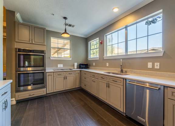 Community kitchen in the grand ballroom with stainless steel appliances, an oven, and coffee machine at Encore at Buckingham apartments in Richardson, TX