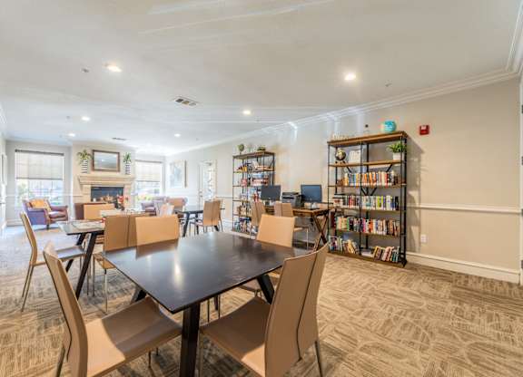 Game room and library with a selection of books, a computer center, and board games at Encore at Buckingham apartments in Richardson, TX