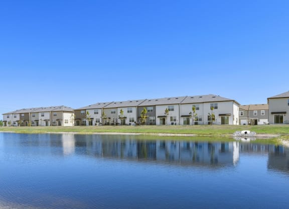 a lake sits in front of a row of townhomes at Beacon at Arbours, Ruskin, FL